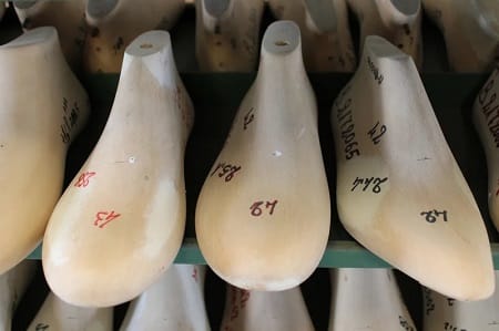 Forme in legno numerate a mano, allineate sulla mensola della bottega